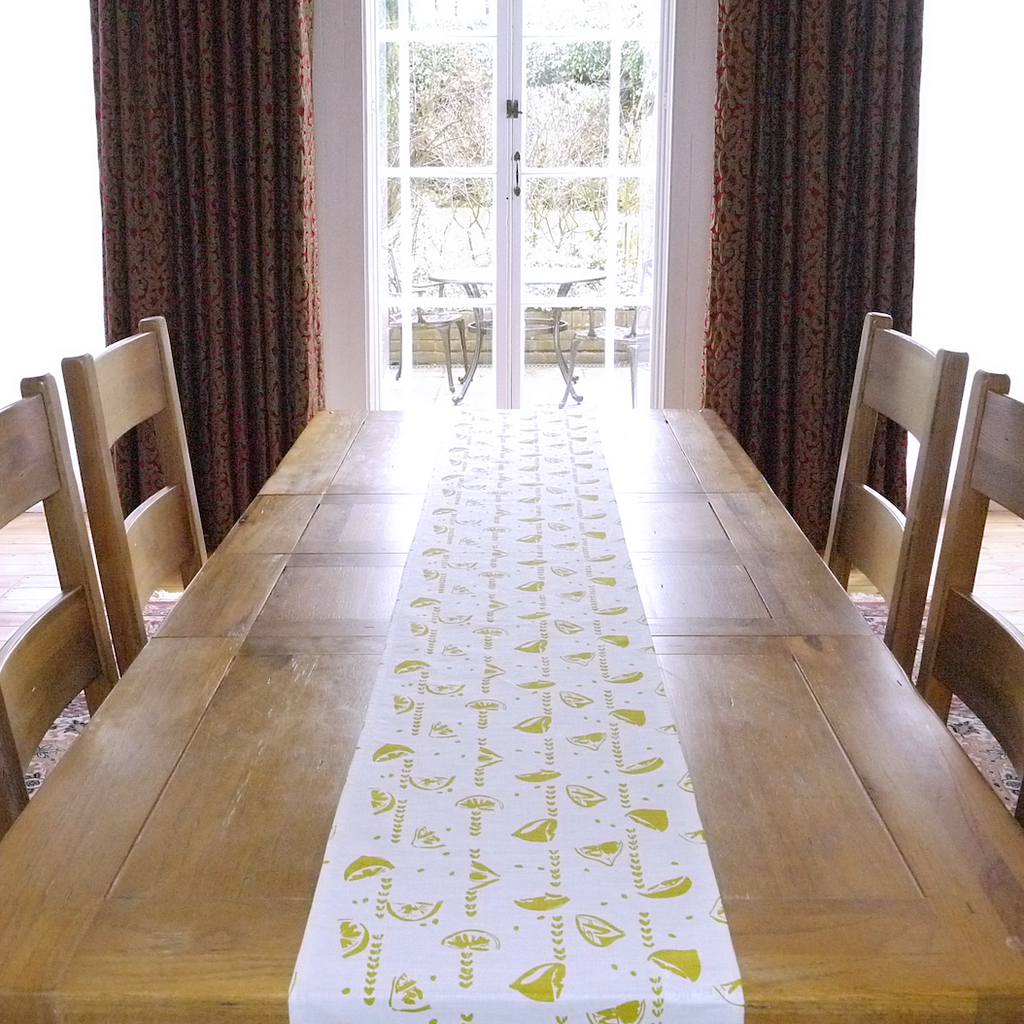 Table runner in linen with screen printed lemons design, washable with hemmed edge 215 x 32cm. Created and made by Curious Lions in the UK.